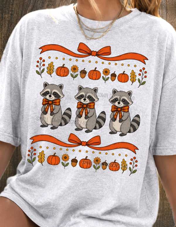 Fall Raccoon Trio Graphic T-Shirt design shown on a model